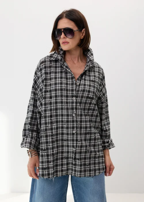 Oversize’owa koszula damska w czarno-białą kratę z efektem delikatnych przetarć i surowym wykończeniem. Luźny fason w stylu grunge świetnie komponuje się z jeansami wide leg i miejskimi stylizacjami casual.