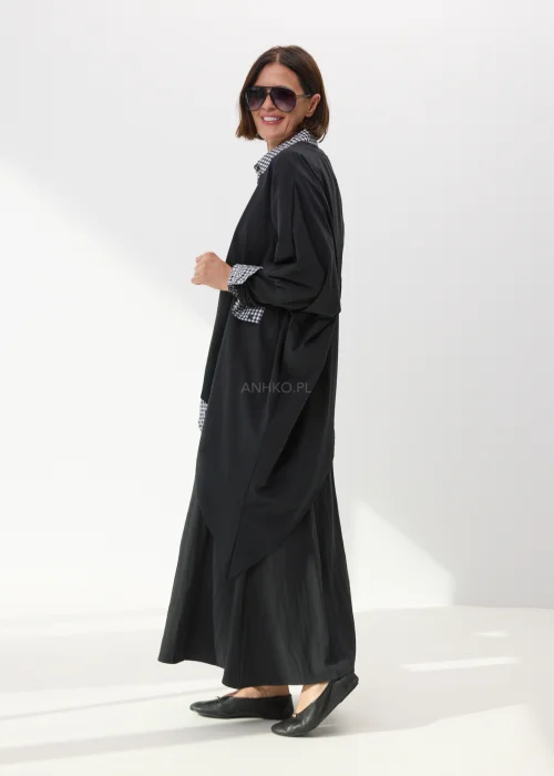 Czarna długa spódnica damska o rozkloszowanym fasonie z lekkiego materiału w minimalistycznym eleganckim stylu.