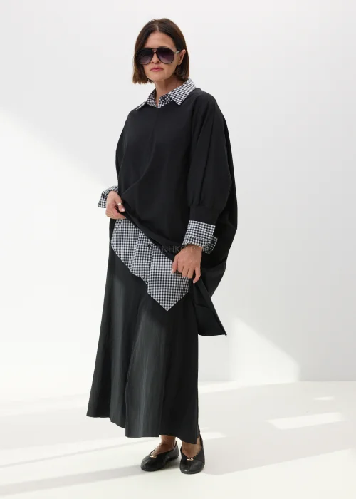 Czarna długa spódnica damska o rozkloszowanym fasonie z lekkiego materiału w minimalistycznym eleganckim stylu.