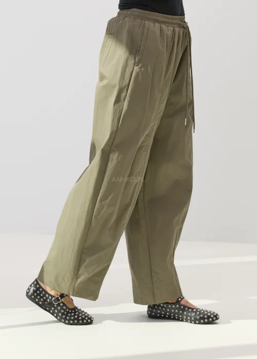 Damskie spodnie khaki z szeroką nogawką i elastyczną talią ze sportowym sznurkiem w casualowym stylu.