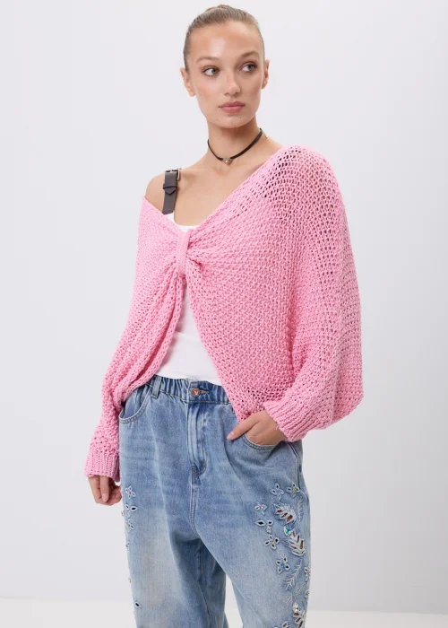 Różowy sweter damski o ażurowym splocie z luźnym fasonem i szerokimi rękawami. Model można nosić klasycznie lub jako narzutkę z efektownym wiązaniem z przodu.