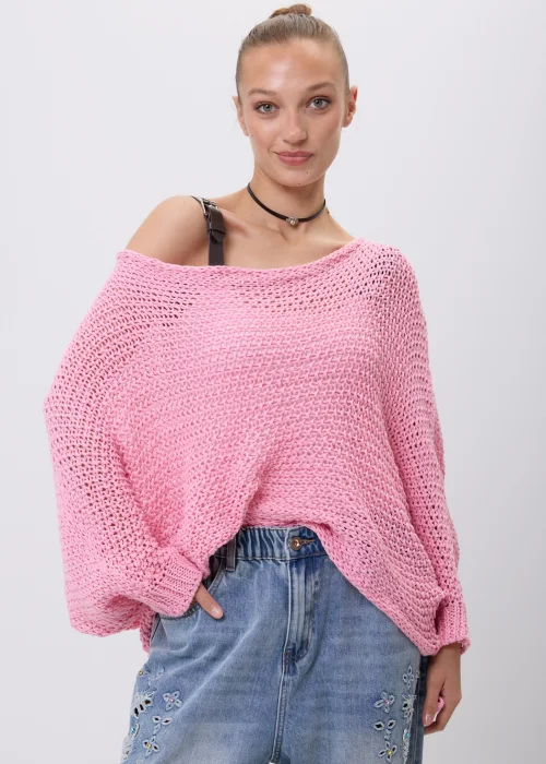 Różowy sweter damski o ażurowym splocie z luźnym fasonem i szerokimi rękawami. Model można nosić klasycznie lub jako narzutkę z efektownym wiązaniem z przodu.