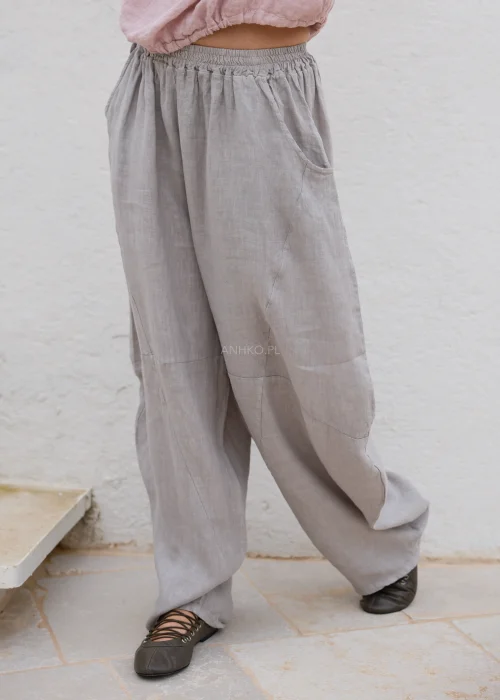 Taupe lniane spodnie damskie o luźnym fasonie z elastyczną talią i kieszeniami. Wygodny model oversize w naturalnej, minimalistycznej stylizacji.