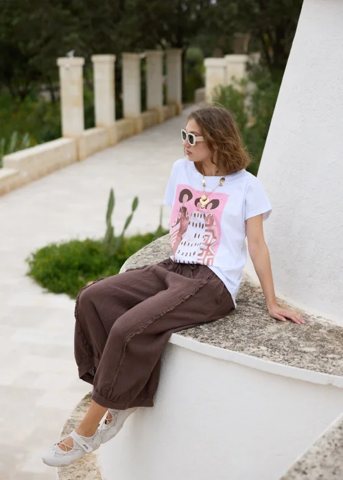 Biały T-shirt damski z różowym nadrukiem inspirowanym sztuką i luźnym fasonem casual.
