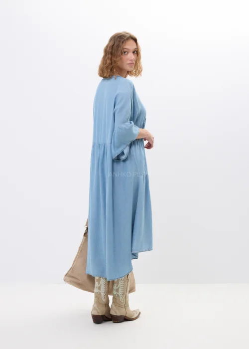 Jasnoniebieska sukienka jeansowa oversize z falbanami i dekoltem V. Zwiewny model z ozdobnymi detalami idealny do boho i casualowych stylizacji.