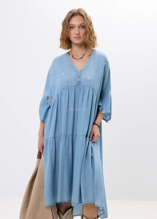 Jasnoniebieska sukienka jeansowa oversize z falbanami i dekoltem V. Zwiewny model z ozdobnymi detalami idealny do boho i casualowych stylizacji.