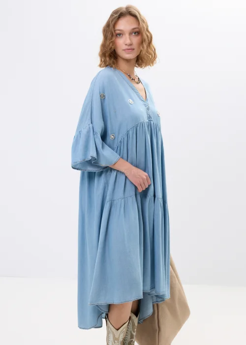 Jasnoniebieska sukienka jeansowa oversize z falbanami i dekoltem V. Zwiewny model z ozdobnymi detalami idealny do boho i casualowych stylizacji.