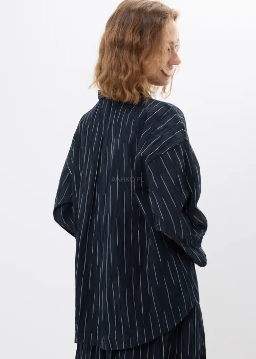 Czarno-biała marynarka oversize w delikatne paski z lekkiego materiału o nowoczesnym fasonie. Luźny model z długim rękawem idealny do eleganckich i casualowych stylizacji.