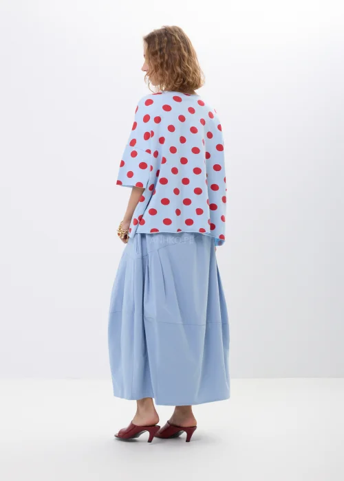 Niebieska bluzka oversize w czerwone grochy z krótkim rękawem i luźnym fasonem. Lekki materiał pięknie układa się na sylwetce, tworząc kobiecą stylizację w retro klimacie z wyrazistym printem.