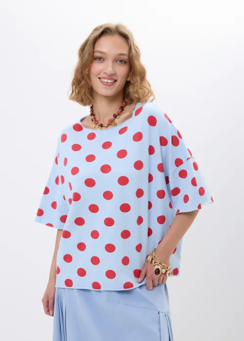 Niebieska bluzka oversize w czerwone grochy z krótkim rękawem i luźnym fasonem. Lekki materiał pięknie układa się na sylwetce, tworząc kobiecą stylizację w retro klimacie z wyrazistym printem.