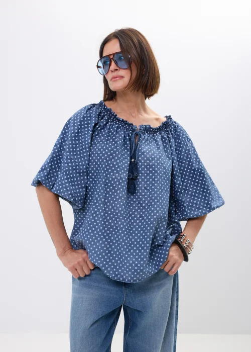 Bluzka damska oversize w kolorze granatowym w drobne groszki. Zwiewny model z szerokimi rękawami i wiązaniem przy dekolcie w stylu boho świetnie komponuje się z jeansami oraz casualowymi stylizacjami.