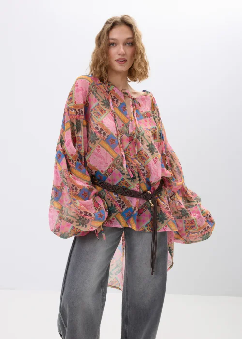 Bluzka damska oversize w stylu boho z multikolorowym printem patchworkowym w odcieniach różu, pomarańczu i brązu. Zwiewny model z szerokimi rękawami oraz wiązaniem w talii świetnie uzupełnia casualowe i artystyczne stylizacje.
