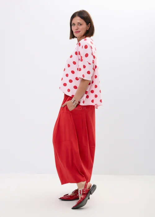 Różowa bluzka oversize w czerwone grochy z szerokim rękawem i minimalistycznym dekoltem. Kobiecy model idealny do  stylizacji w klimacie retro chic i casual fashion.
