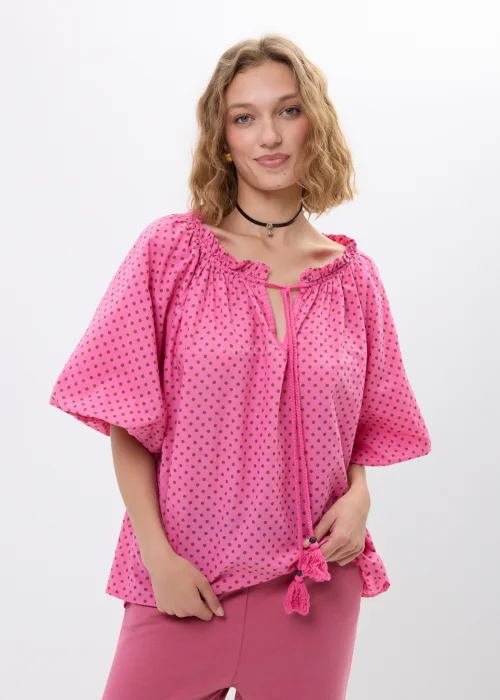 Różowa bluzka damska w drobne groszki z szerokimi rękawami i wiązaniem przy dekolcie. Luźny fason w stylu boho.