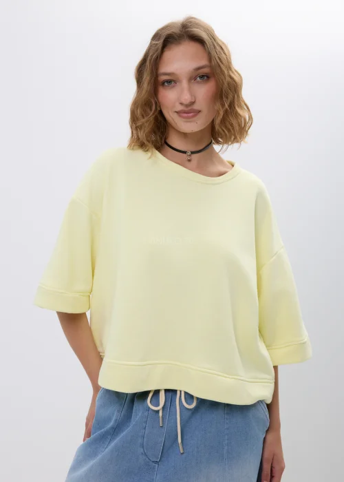 Żółta bluza oversize z krótkim rękawem i ściągaczem u dołu. Luźny fason w pastelowym odcieniu, idealny na co dzień.