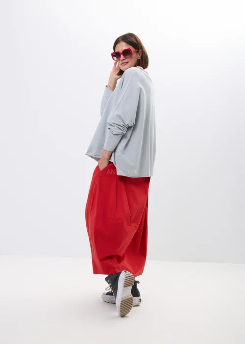 Szara bluza oversize z ozdobnym prążkowanym dekoltem i czerwonym akcentem. Luźny fason z długim rękawem, idealny do codziennych stylizacji.