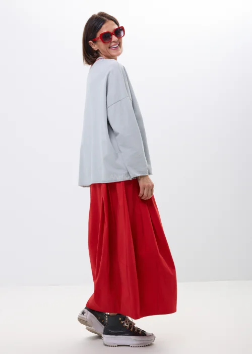 Szara bluza oversize z ozdobnym prążkowanym dekoltem i czerwonym akcentem. Luźny fason z długim rękawem, idealny do codziennych stylizacji.