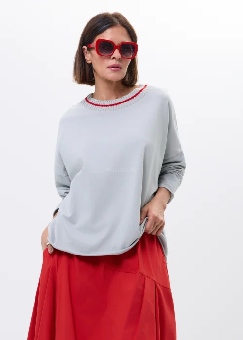 Szara bluza oversize z ozdobnym prążkowanym dekoltem i czerwonym akcentem. Luźny fason z długim rękawem, idealny do codziennych stylizacji.