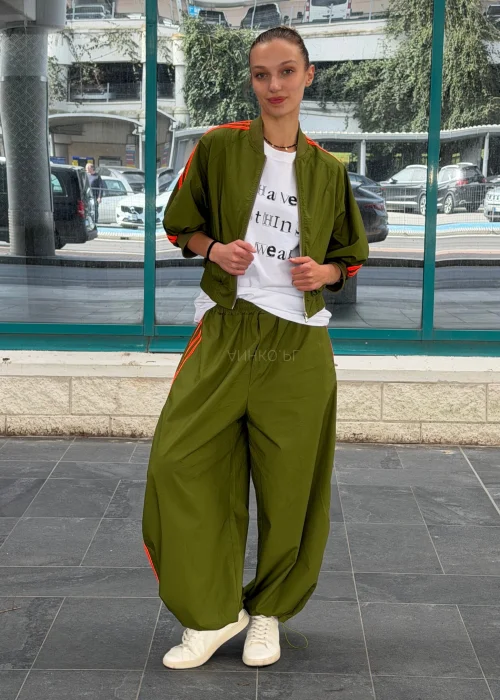 Biały T-shirt damski z nadrukiem „I Have Nothing To Wear” w czarnym kolorze. Luźny model casual zestawiony z zielonymi spodniami i okularami przeciwsłonecznymi.