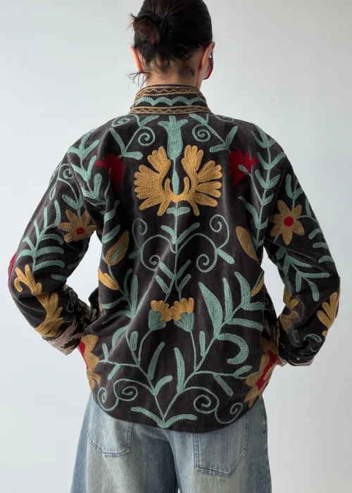 Żakiet damski w kolorze grafitowym z bogatym haftem roślinnym w odcieniach mięty, musztardy i bordo. Artystyczny model w stylu boho z dekoracyjnymi kwiatowymi motywami.