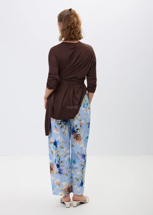 Brązowa bluzka z efektownym wiązaniem w talii i luźnym fasonem oversize. Model z długim rękawem oraz asymetrycznym drapowaniem podkreśla sylwetkę i tworzy elegancką, kobiecą stylizację.