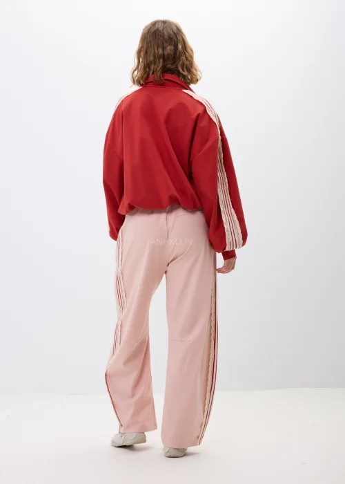 Czerwona bluza damska z ozdobnymi zapięciami inspirowanymi stylem orientalnym oraz dekoracyjnymi lampasami na rękawach. Modny oversize z wysoką stójką i efektownymi detalami podkreślającymi wyjątkowy charakter stylizacji.