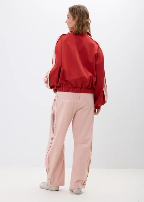 Czerwona bluza damska z ozdobnymi zapięciami inspirowanymi stylem orientalnym oraz dekoracyjnymi lampasami na rękawach. Modny oversize z wysoką stójką i efektownymi detalami podkreślającymi wyjątkowy charakter stylizacji.