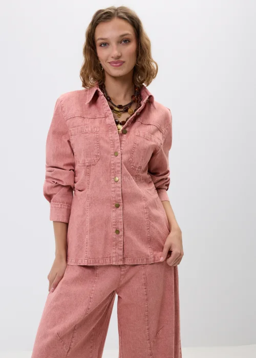 Różowa koszula jeansowa z długim rękawem, kołnierzykiem i zapięciem na napy. Model z kieszeniami na piersi i dopasowanym fasonem tworzy modną stylizację denim total look w kobiecym wydaniu.
