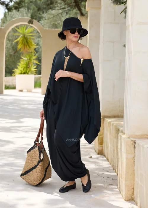 Czarna oversize’owa bluzka o asymetrycznym fasonie z efektownym dekoltem opadającym na jedno ramię. Zwiewny materiał i luźny krój tworzą elegancką, nowoczesną stylizację.