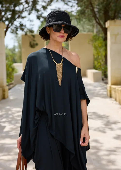 Czarna oversize’owa bluzka o asymetrycznym fasonie z efektownym dekoltem opadającym na jedno ramię. Zwiewny materiał i luźny krój tworzą elegancką, nowoczesną stylizację.