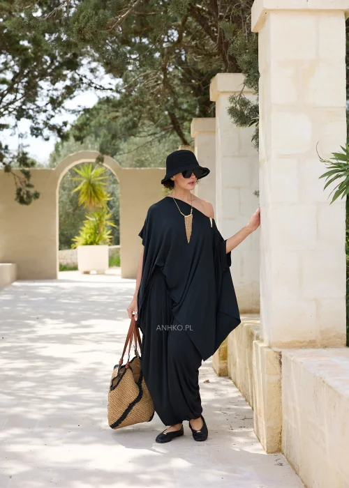 Czarna oversize’owa bluzka o asymetrycznym fasonie z efektownym dekoltem opadającym na jedno ramię. Zwiewny materiał i luźny krój tworzą elegancką, nowoczesną stylizację.
