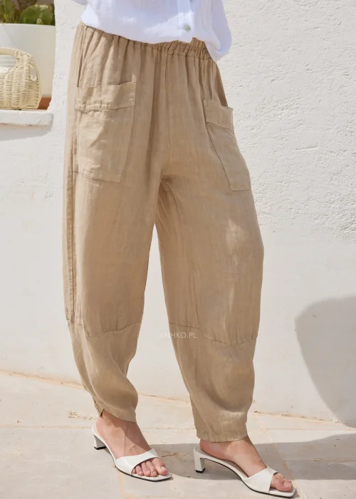 Spodnie lniane camel o swobodnym kroju z obniżoną linią nogawki i praktycznymi kieszeniami. Lekki materiał i komfortowy fason doskonale sprawdzają się w codziennych stylizacjach.