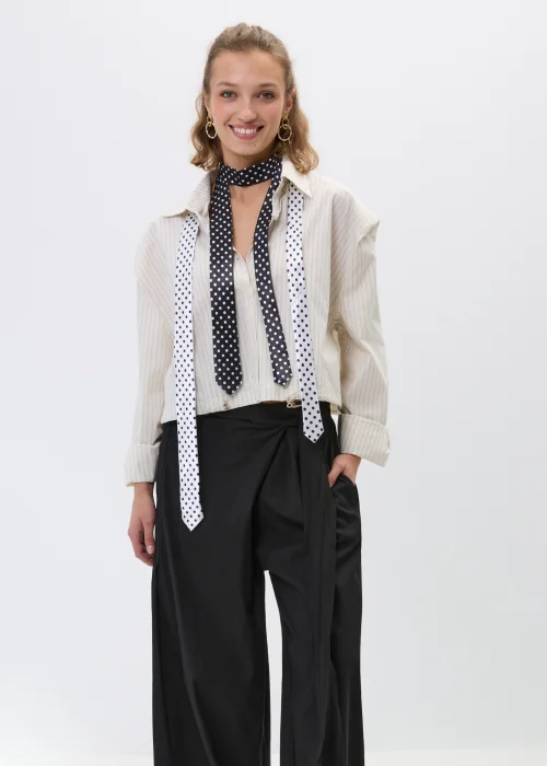 Elegancki krawat w kolorze czarnym z klasycznym printem w białe grochy, idealny do koszul, marynarek oraz stylizacji w klimacie vintage i modern chic.