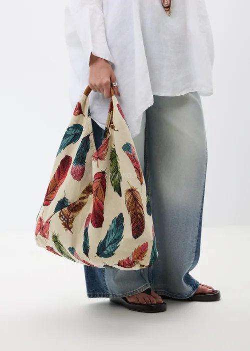 Duża materiałowa torba shopper w kremowym kolorze ozdobiona wielobarwnym wzorem piór. Pojemny model z wygodnymi uchwytami, idealny do codziennych stylizacji, na zakupy, spacer lub wyjazd.