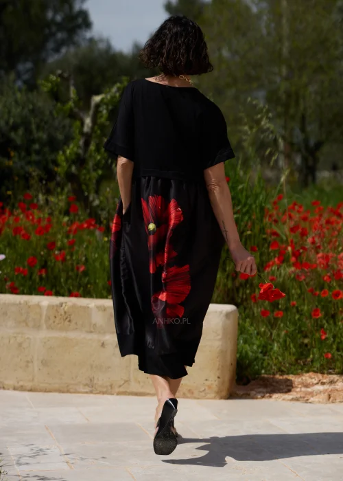 Czarna sukienka midi z efektownym czerwonym motywem maków, luźnym fasonem i praktycznymi kieszeniami. Elegancki model z krótkim rękawem idealny do codziennych i wyjątkowych stylizacji w kobiecym, artystycznym stylu.