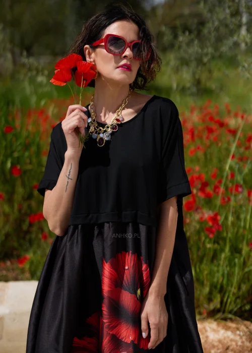 Czarna sukienka midi z efektownym czerwonym motywem maków, luźnym fasonem i praktycznymi kieszeniami. Elegancki model z krótkim rękawem idealny do codziennych i wyjątkowych stylizacji w kobiecym, artystycznym stylu.