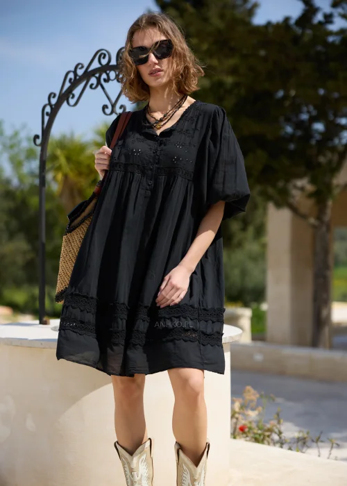 Czarna sukienka boho z haftowanymi detalami i koronkowymi wstawkami, o luźnym fasonie i bufiastych rękawach. Kobiecy model mini idealny do letnich stylizacji z plecioną torbą i dodatkami w naturalnym stylu.