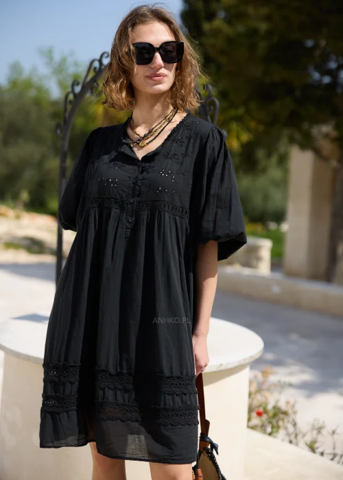 Czarna sukienka boho z haftowanymi detalami i koronkowymi wstawkami, o luźnym fasonie i bufiastych rękawach. Kobiecy model mini idealny do letnich stylizacji z plecioną torbą i dodatkami w naturalnym stylu.