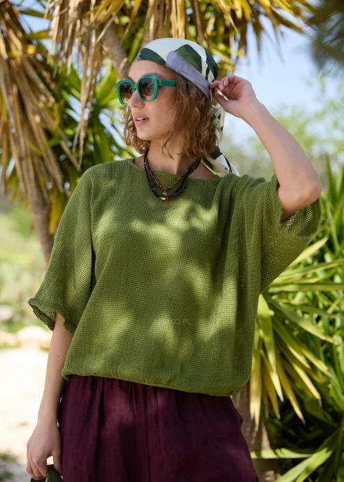Oliwkowy ażurowy sweter damski oversize z krótkim rękawem i okrągłym dekoltem. Lekki, siateczkowy splot nadaje modelowi swobodny charakter i doskonale sprawdza się w casualowych, warstwowych stylizacjach.