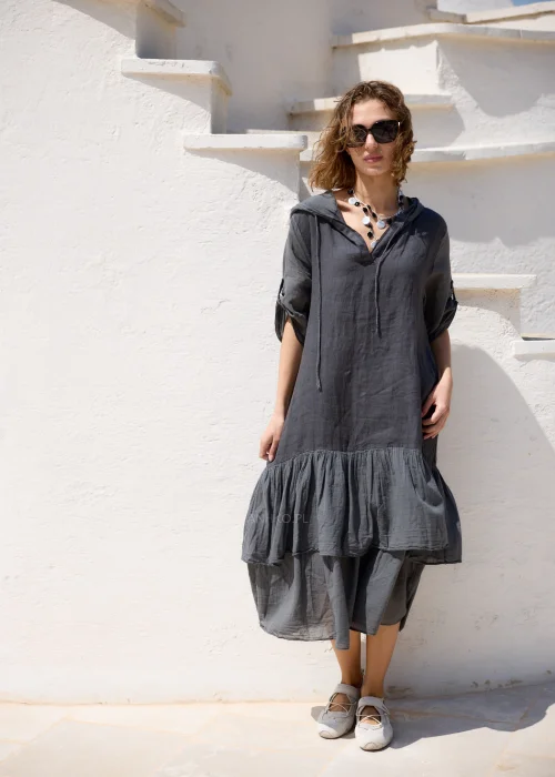 Lniana sukienka maxi z kapturem w grafitowym kolorze, z dekoracyjną falbaną u dołu i podwijanymi rękawami. Luźny fason w stylu boho zapewnia wygodę i doskonale sprawdza się w naturalnych, codziennych stylizacjach.