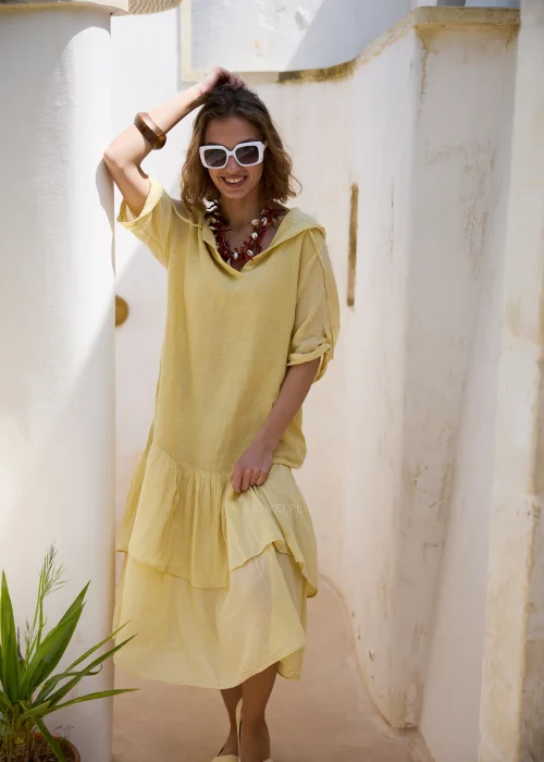 Jasnożółta sukienka midi z kapturem, falbaną u dołu i podpinanymi rękawami 3/4. Luźny model w stylu boho, idealny na wakacyjne spacery i codzienne letnie stylizacje.