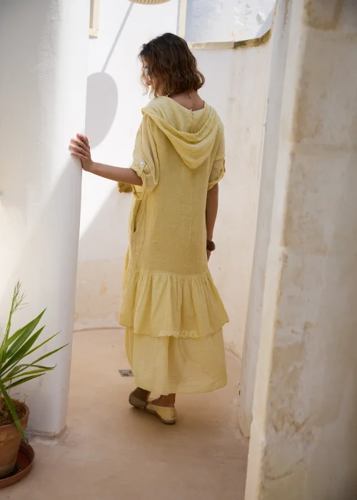 Jasnożółta sukienka midi z kapturem, falbaną u dołu i podpinanymi rękawami 3/4. Luźny model w stylu boho, idealny na wakacyjne spacery i codzienne letnie stylizacje.