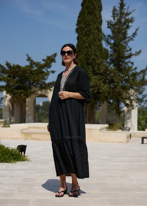 Czarna sukienka maxi w stylu boho z ażurowymi haftami, dekoltem V i szerokimi rękawami 3/4. Zwiewny model o luźnym fasonie, idealny do codziennych i wakacyjnych stylizacji.