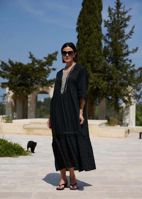 Czarna sukienka maxi w stylu boho z ażurowymi haftami, dekoltem V i szerokimi rękawami 3/4. Zwiewny model o luźnym fasonie, idealny do codziennych i wakacyjnych stylizacji.