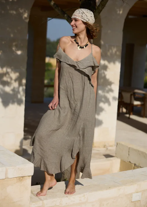 Lniana sukienka maxi w odcieniu taupe z asymetryczną falbaną przy dekolcie i dole oraz cienkimi ramiączkami. Zwiewny model w stylu boho, idealny na wakacyjne stylizacje i codzienne letnie wyjścia.
