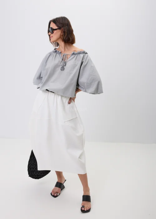 Szara bluzka damska o luźnym fasonie z bufiastymi rękawami i wiązaniem przy dekolcie zakończonym chwostami. Lekki model w stylu boho, idealny do spódnic i spodni w codziennych oraz eleganckich stylizacjach.