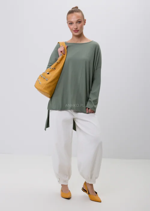 Oliwkowa damska bluzka oversize z długim rękawem i asymetrycznym dołem, wykonana z miękkiej dzianiny. Minimalistyczna stylizacja casual z białymi spodniami, idealna na co dzień i do nowoczesnych zestawów.