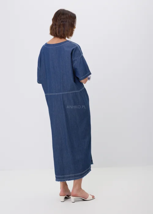 Jeansowa sukienka maxi oversize z krótkim, szerokim rękawem, ozdobiona dekoracyjnymi przeszyciami oraz naszywanymi aplikacjami w kształcie okręgów z postrzępionym wykończeniem. Luźny fason zapewnia wygodę i tworzy nowoczesną, casualową stylizację.
