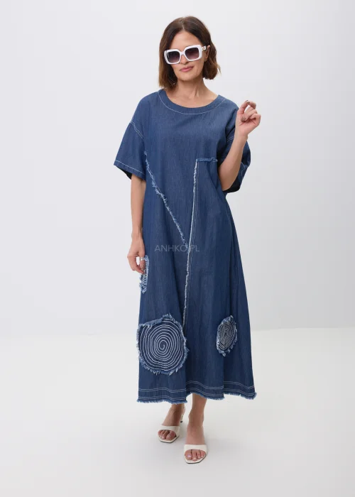 Jeansowa sukienka maxi oversize z krótkim, szerokim rękawem, ozdobiona dekoracyjnymi przeszyciami oraz naszywanymi aplikacjami w kształcie okręgów z postrzępionym wykończeniem. Luźny fason zapewnia wygodę i tworzy nowoczesną, casualową stylizację.