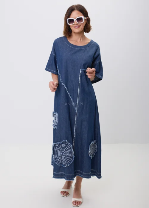 Jeansowa sukienka maxi oversize z krótkim, szerokim rękawem, ozdobiona dekoracyjnymi przeszyciami oraz naszywanymi aplikacjami w kształcie okręgów z postrzępionym wykończeniem. Luźny fason zapewnia wygodę i tworzy nowoczesną, casualową stylizację.